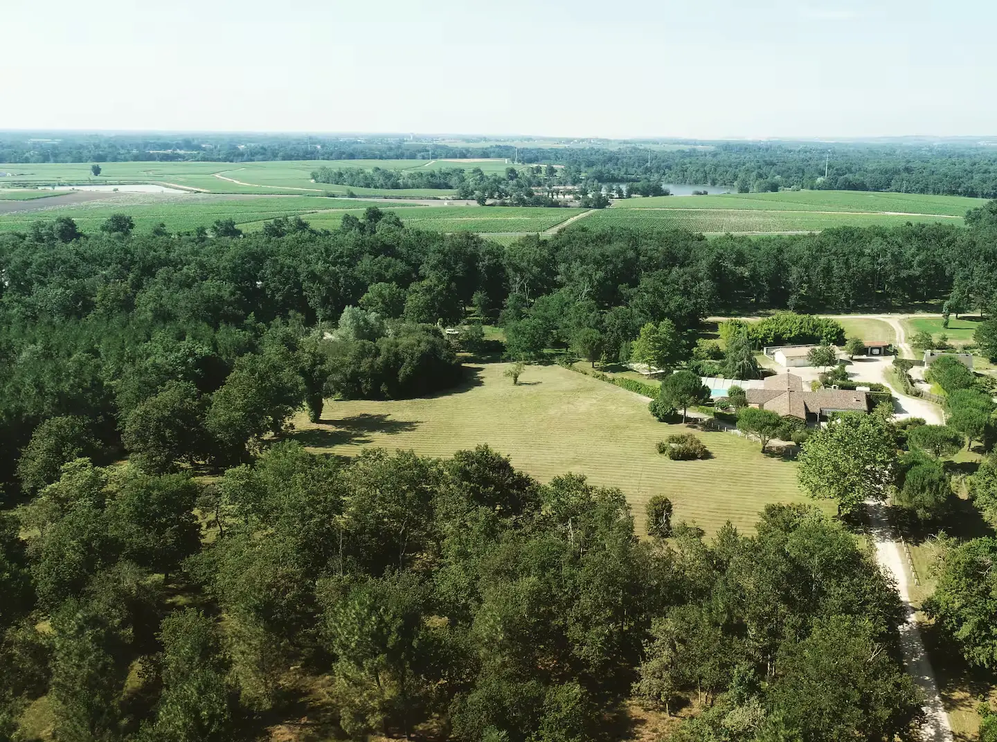 Aerial view of the estate at golden hour, showing the tiled roofline, open pool and surrounding grounds