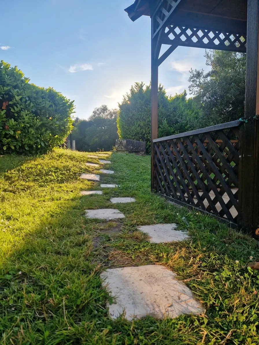 A stepping-stone path through the garden leading toward a wooden gazebo